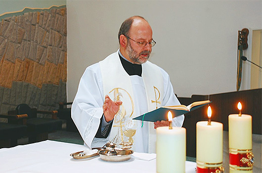 O. Artur błogosławi wodę przed udzieleniem sakramentu chrztu